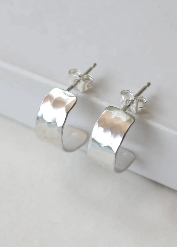 Silver hoop earrings on a white surface