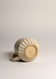 Ceramic ring with sunburst design on a light gray background