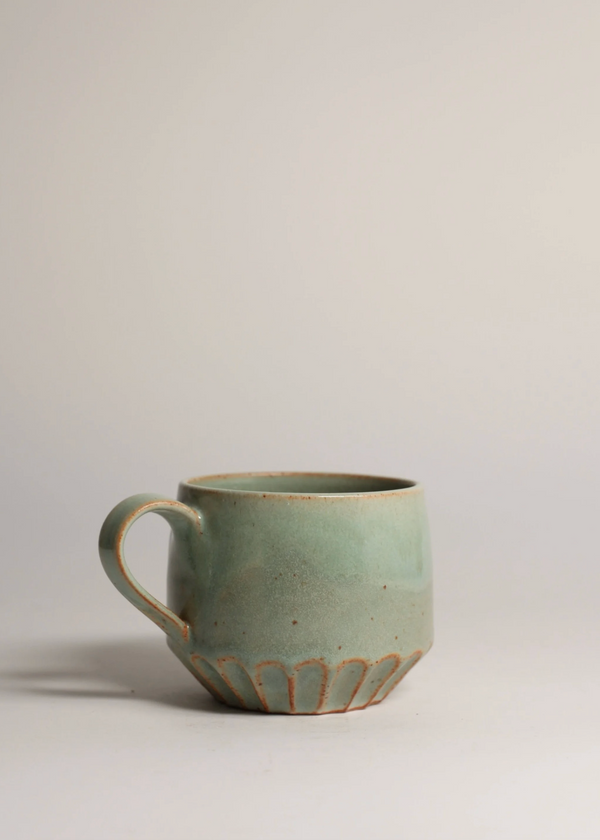 Green ceramic mug on a light gray background