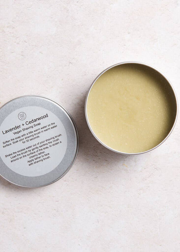 Open tin of lavender and cedarwood shaving soap on a light background