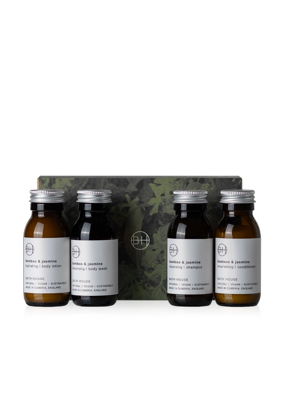 Set of four small bottles with labels and a camouflage-patterned box on a white background