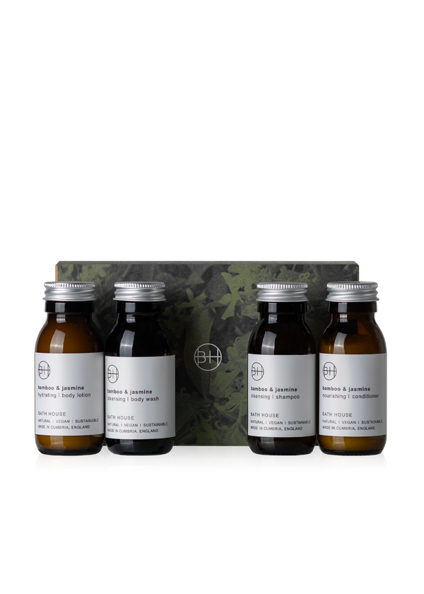Set of four small bottles with labels and a camouflage-patterned box on a white background