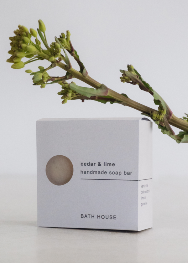 Handmade soap bar packaging with a branch on a light background