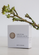 Handmade soap bar packaging with a branch on a light background