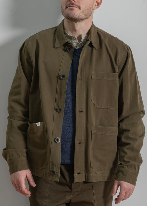 Man wearing a brown jacket and pants against a plain background