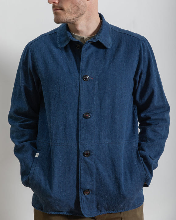 Man wearing a blue jacket with buttons on a plain background