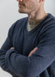 Man wearing a dark blue sweater with a plain background