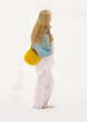 Person wearing a blue knitted shawl and yellow bag on a white background