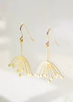 Gold earrings with a delicate design on a light gray background