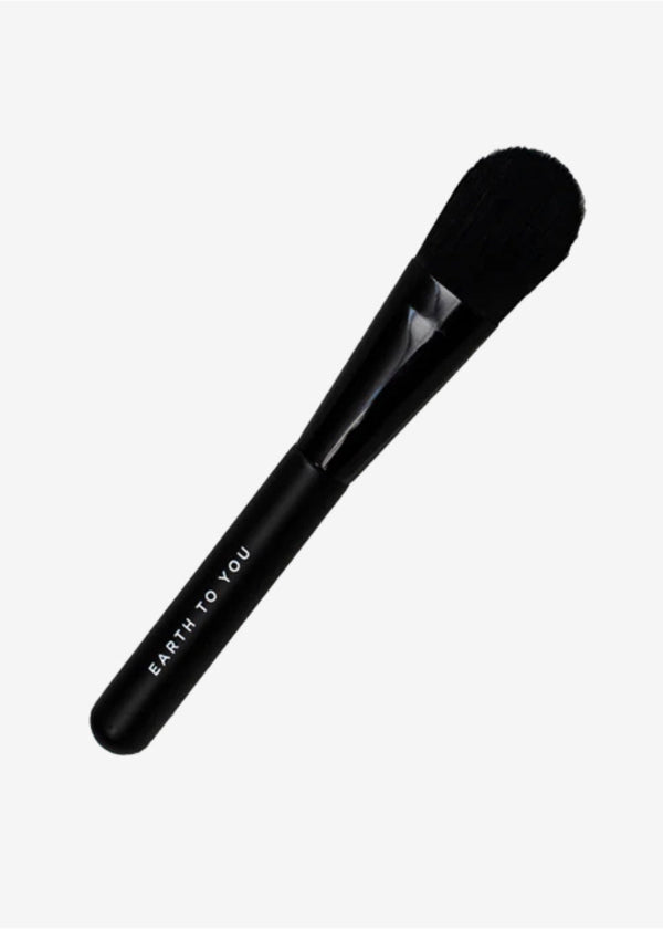 Black makeup brush with 'Earth to You' branding on a white background