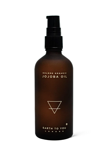 A brown bottle with a black spray nozzle labeled as Jojoba Oil, with the brand 'Earth to You' printed on it.