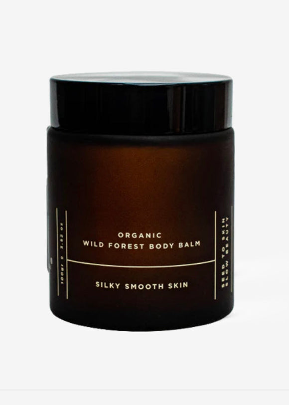 This image features a sleek jar of "Organic Wild Forest Body Balm," marketed by Earth To You for silky smooth skin. The jar is dark amber with a simple, elegant white label that highlights the product's organic nature and promotes a sense of natural luxury.