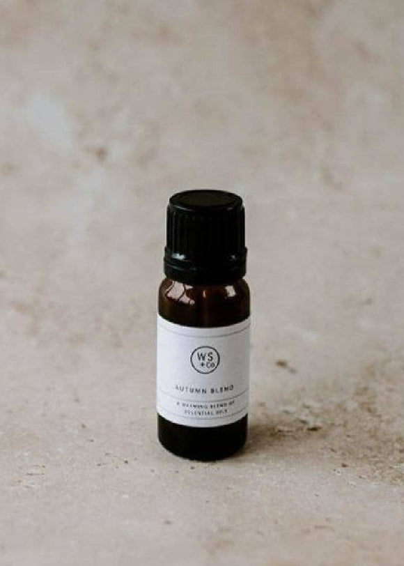 Small brown bottle with a black cap on a beige surface