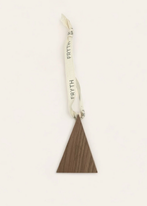 Decorative hanging with a triangle-shaped brown ornament and white ribbon on a beige background