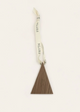 Decorative hanging with a triangle-shaped brown ornament and white ribbon on a beige background