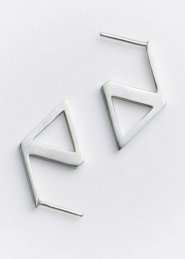 Pair of geometric triangle earrings on a light gray background