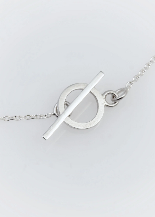 Silver necklace with a unique pendant on a light gray background