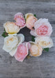 Floral wreath with pink, white, and yellow roses on a wooden surface