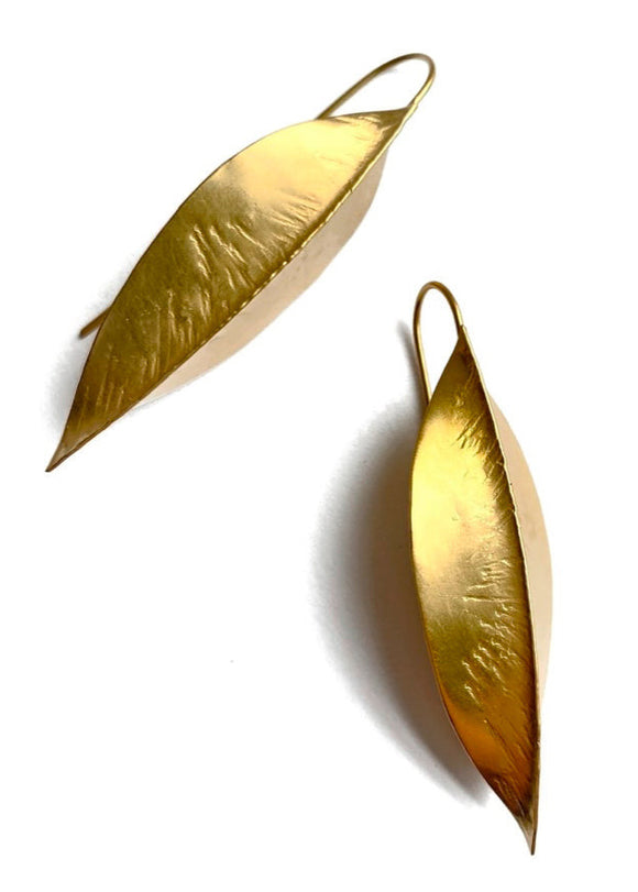 Gold leaf-shaped earrings on a white background