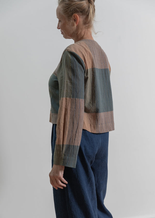 Person wearing a striped shirt and blue pants against a white background