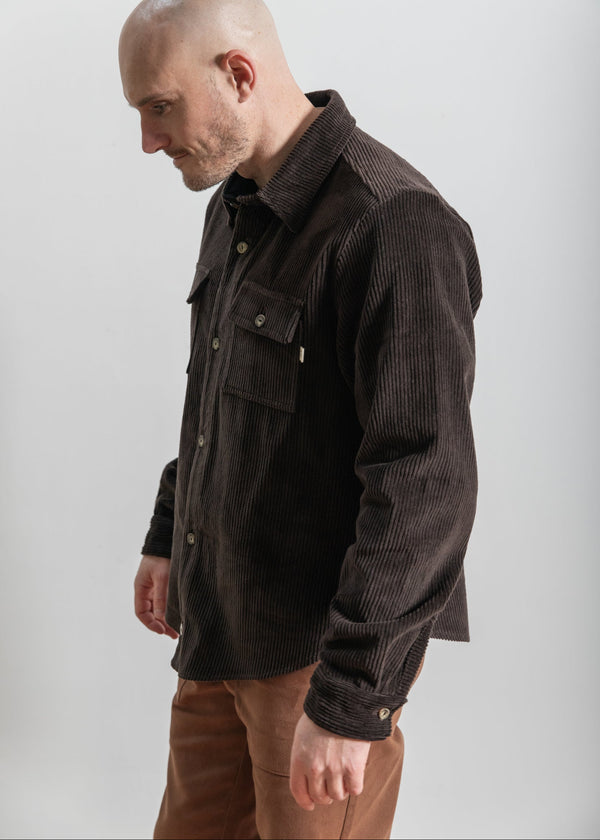 Man wearing a brown corduroy jacket against a white background