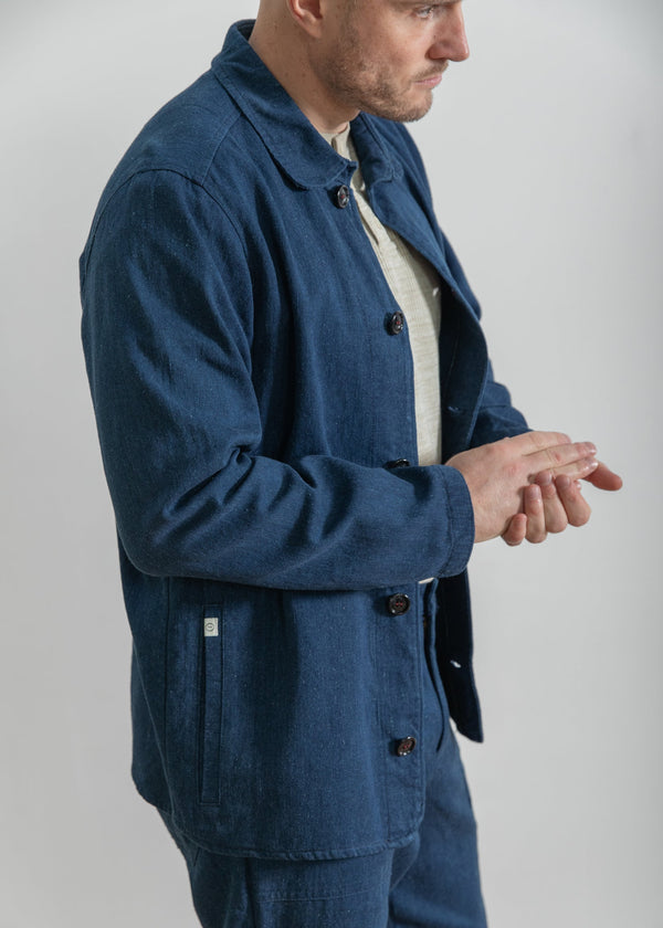 Man wearing a blue jacket and pants on a plain background