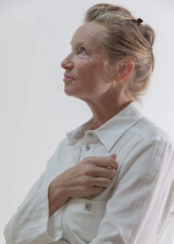 Woman wearing a white shirt against a plain background