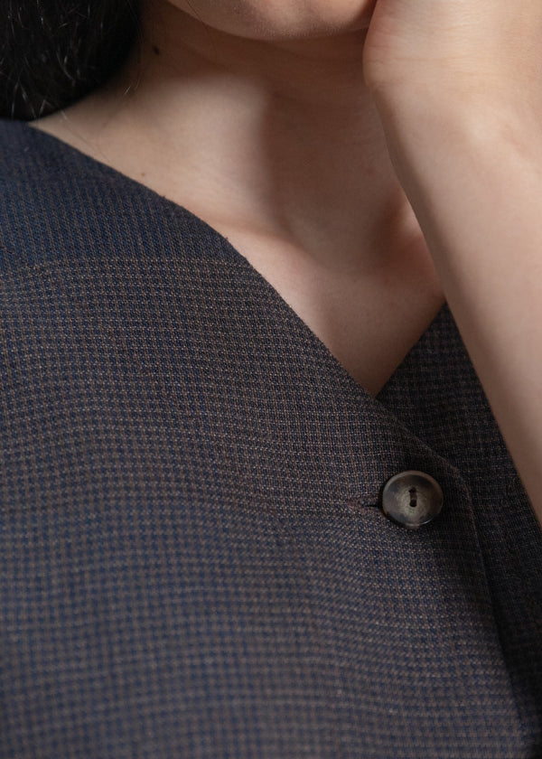 Close-up of a textured gray garment with a button