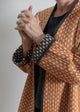 Person wearing a patterned robe with a neutral background