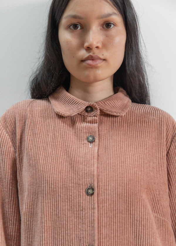 Woman wearing a brown corduroy shirt against a plain background