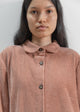 Woman wearing a brown corduroy shirt against a plain background