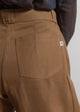 Brown pants with a pocket detail on a plain background