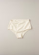A pair of high-waisted beige organic cotton knickers with binding at the waist and legs.