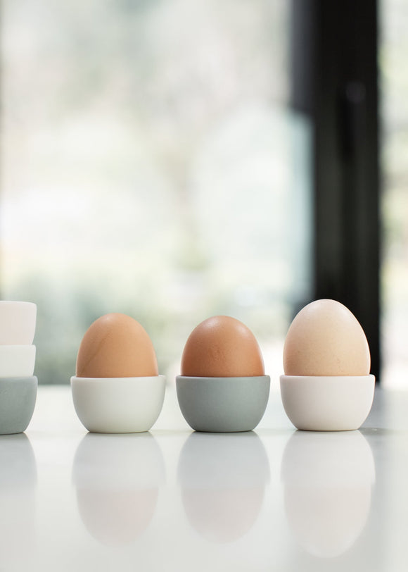 Three eggs on a white surface with a blurred background