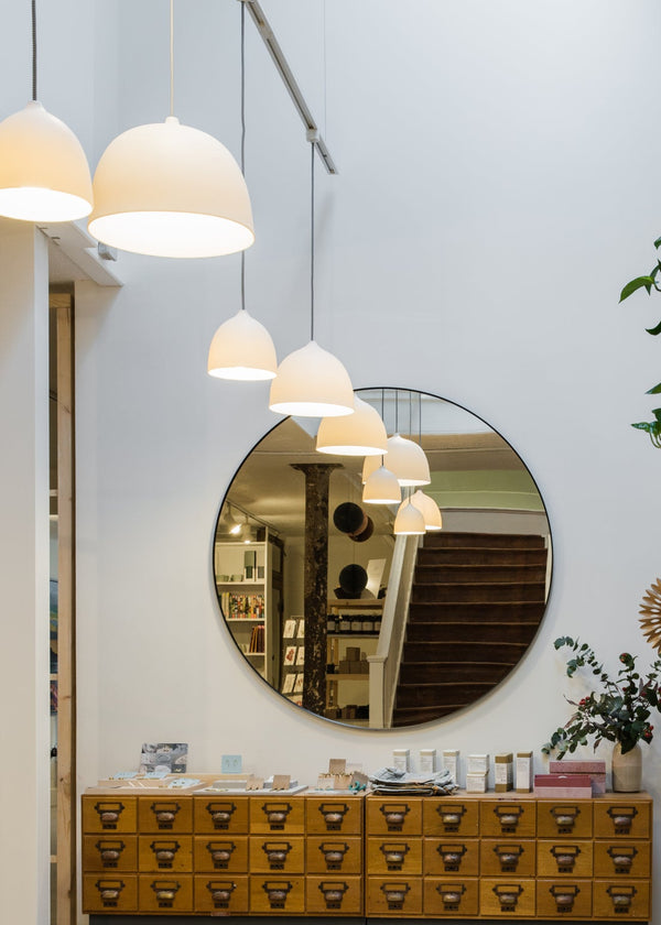 Modern interior design with wooden shelves, round mirror, and decorative items.