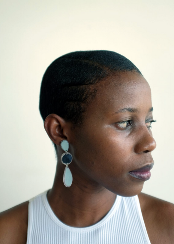 Woman wearing a white sleeveless top with a plain background
