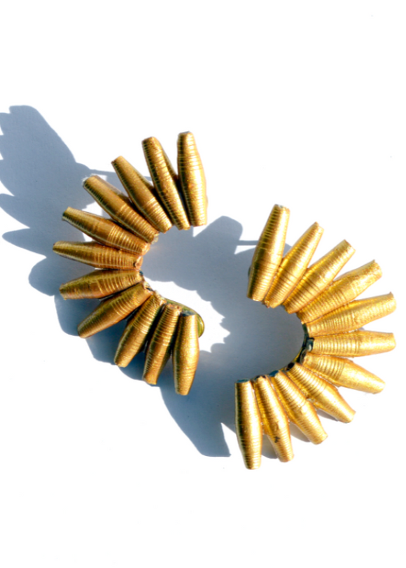 A gold-colored, fan-shaped earring made from recycled paper, displayed on a white background.