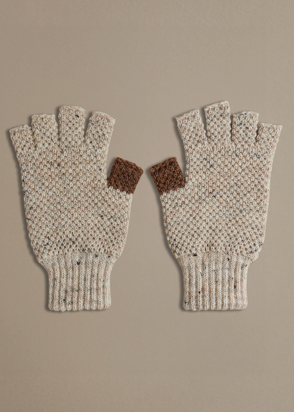 Pair of knitted fingerless gloves with brown accents on a beige background