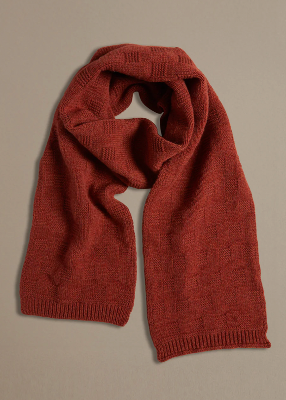 A chunky red garter stitch scarf laid out on a plain surface.