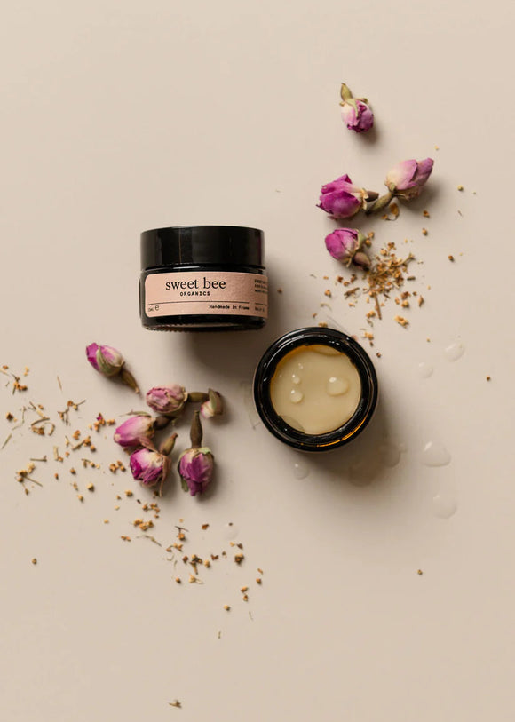 Two jars of 'sweet bee' cream with dried flowers on a beige background