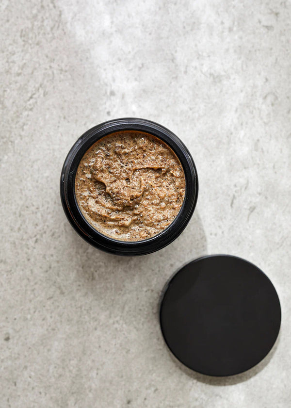 Black container with brown paste on a light gray surface