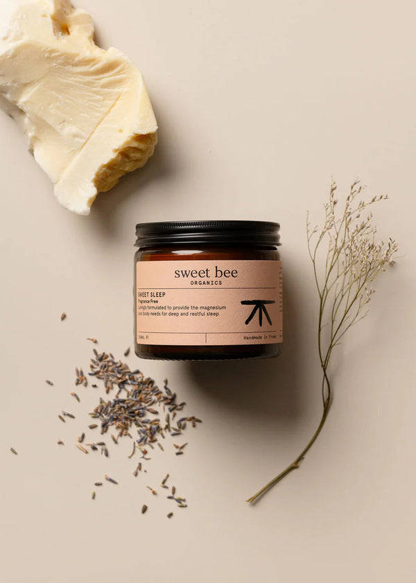 Jar of 'sweet bee' product with lavender and a leaf on a beige background