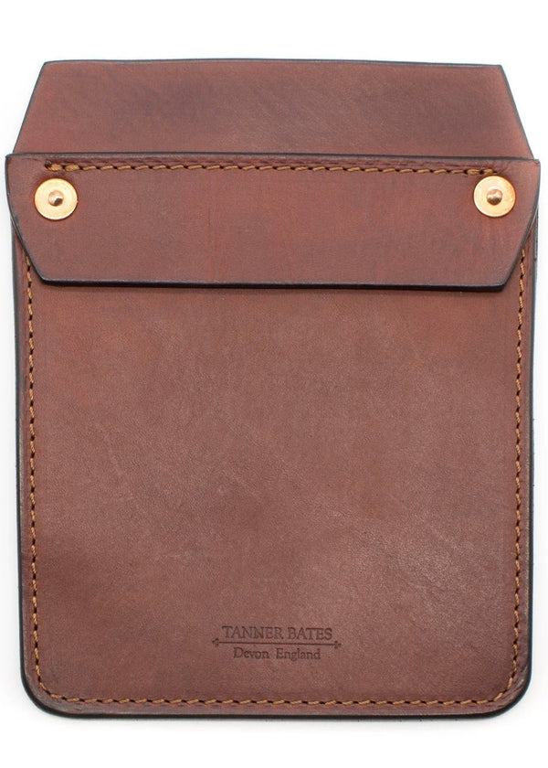A brown leather pocket protector with brass snap closures, featuring the Tanner Bates brand embossed at the bottom.
