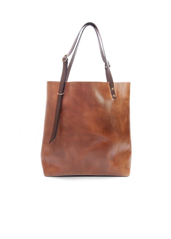 Brown leather tote bag with a strap on a white background