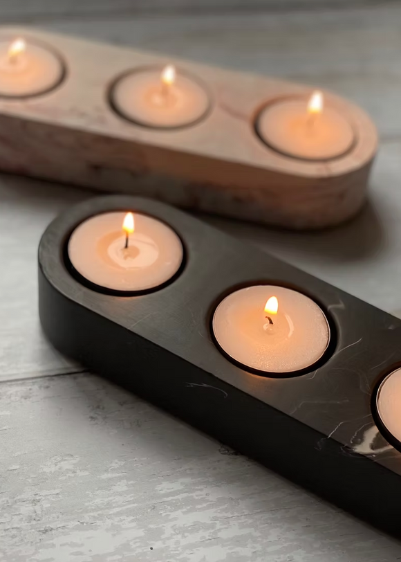 Two candle holders with lit candles on a wooden surface