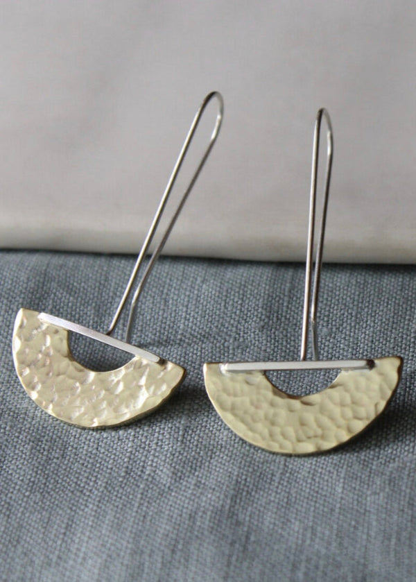 A pair of silver drop earrings with a textured finish, displayed against a grey background.