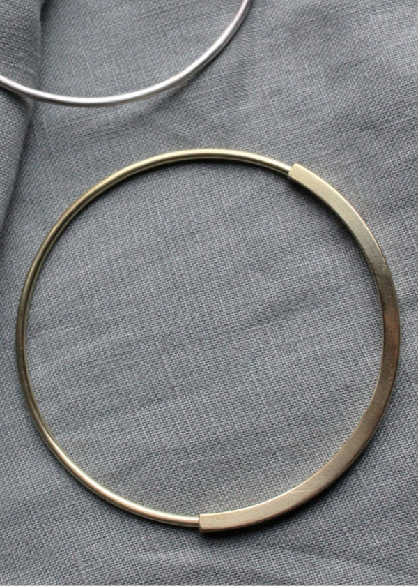Two circular braclets on a gray fabric background