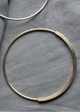 Two circular braclets on a gray fabric background