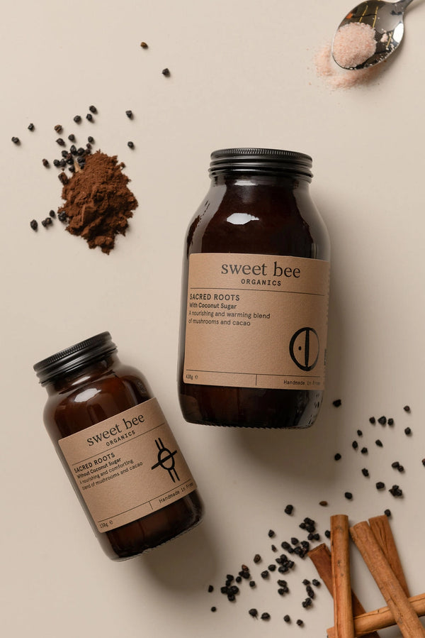 Two 'sweet bee' containers on a beige background with spices and a spoon.