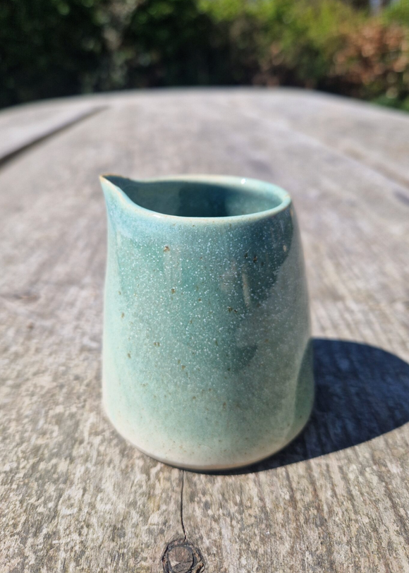 Green ceramic cup on a wooden surface